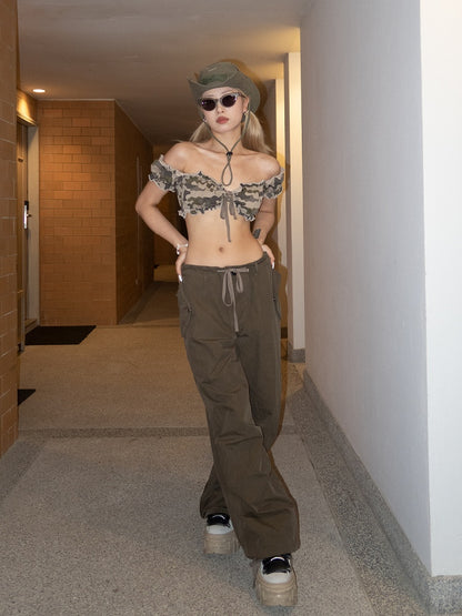 Glamouröses, kurzes, trägerloses Top mit hellem Camouflage-Muster und Rüschenbesatz sowie kurzen Puffärmeln