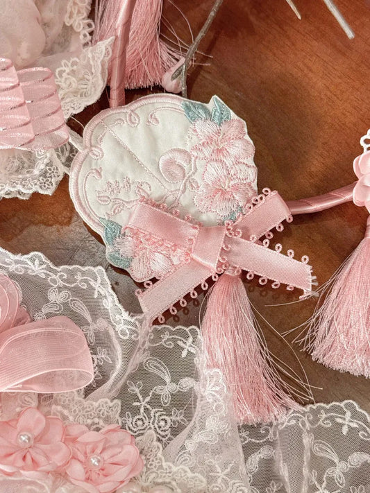 Rosafarbene Brosche mit Blumenstickerei und Quaste