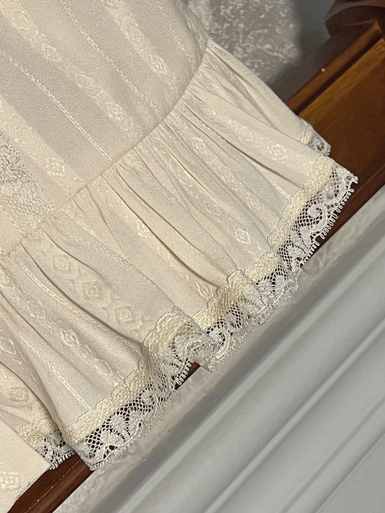 ベージュのフリルネックラインショートパフスリーブブラウス