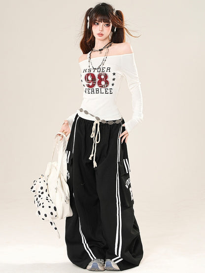 数字をあしらったブラックワイドレッグパンツ、ポケット付きレターカーゴカットプリント、ほろ苦い