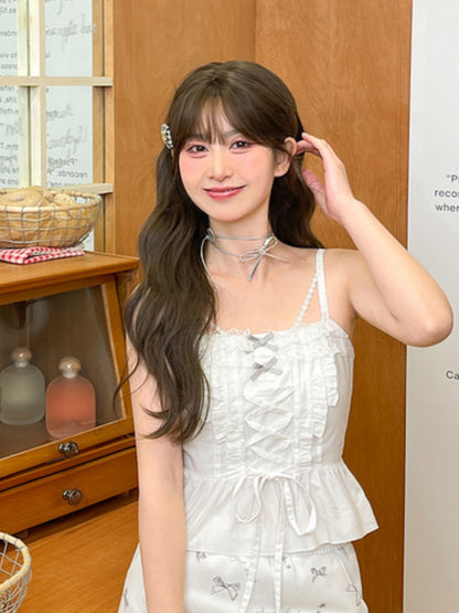 bei weißem Cami-Top mit Rüschen und Spitzenbesatz, Schnürung vorne mit Schleifendetail