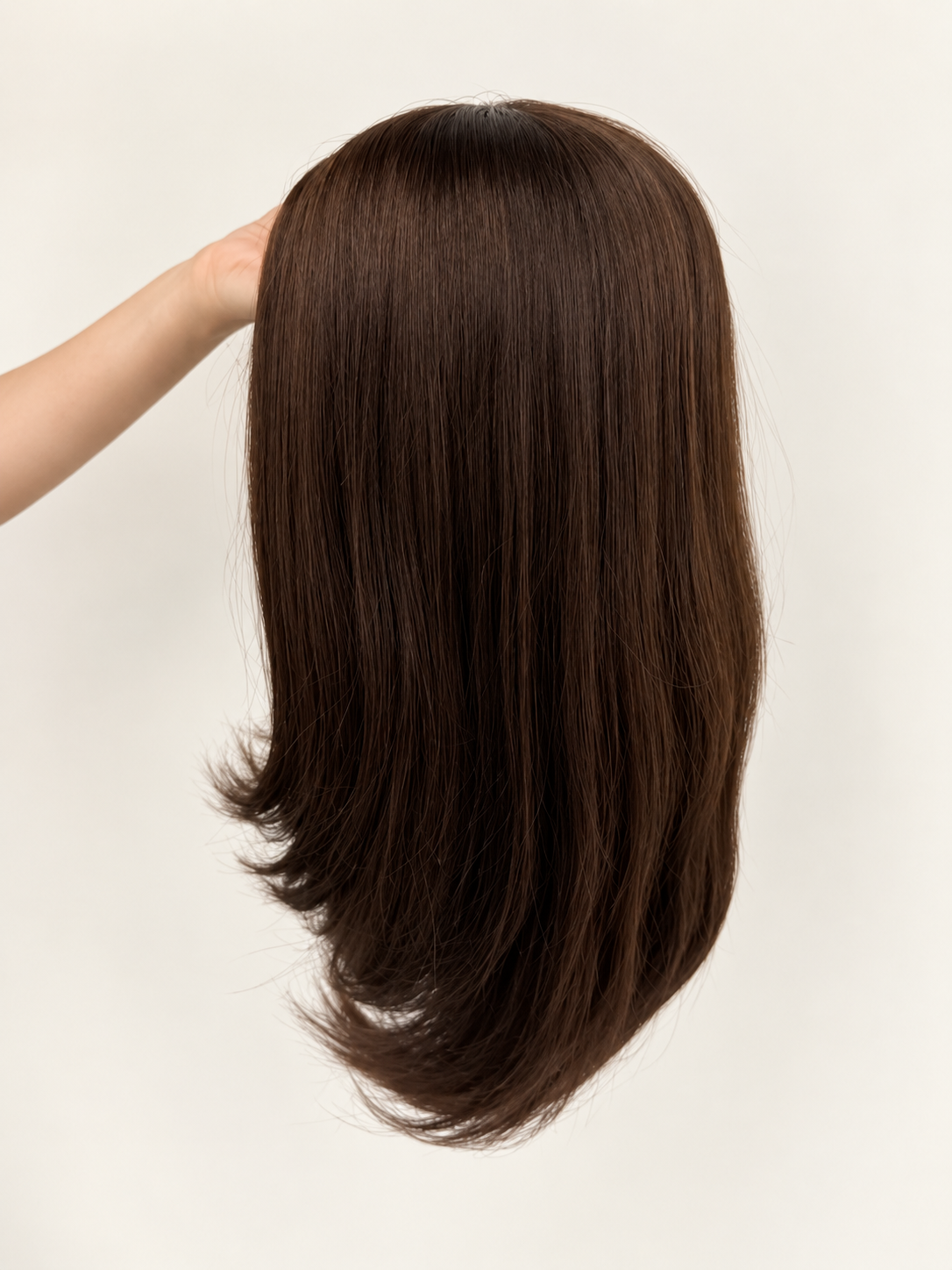 Handheld real product back view of the chocolate brown 14-inch straight synthetic wig showing the natural tapered layers